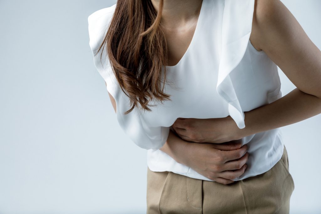 Photo of a woman holding her stomach in pain 