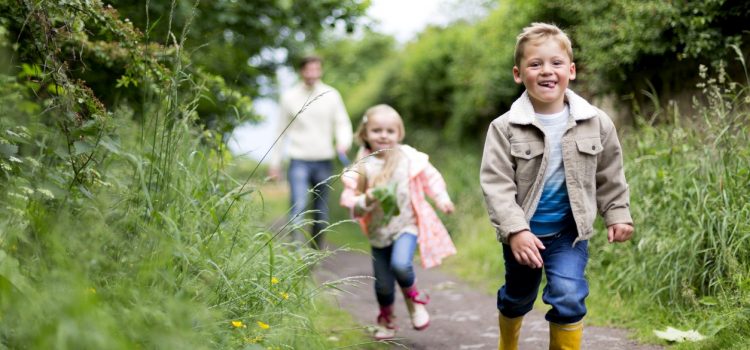 Children and their father going out for a walk.