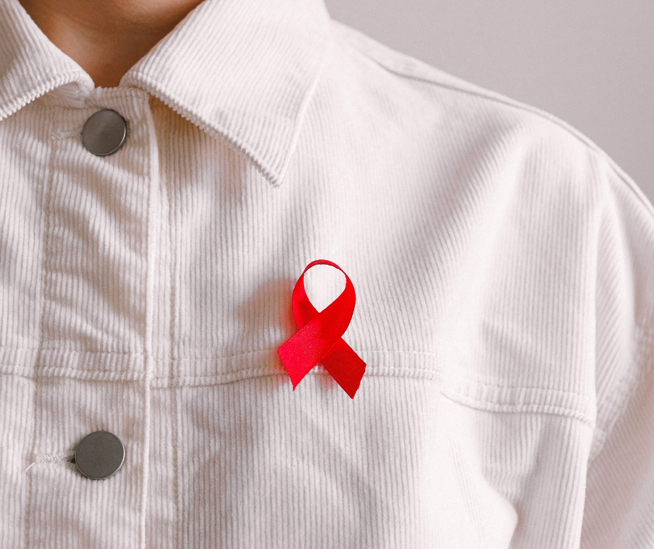 Photo of a person wearing a white jacket with the red HIV awareness ribbon