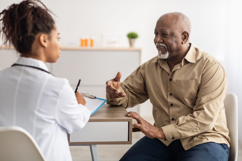 Older man with a clinician in a healthcare setting