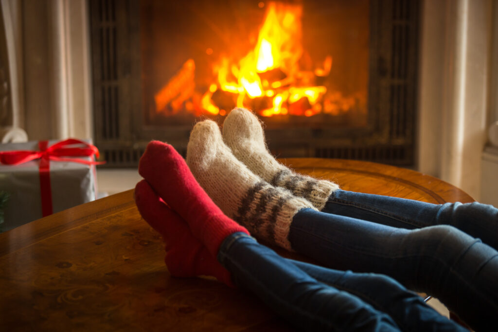Two people warming their feet in front of the fire