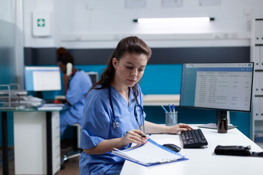 Healthcare worker entering data from physical records