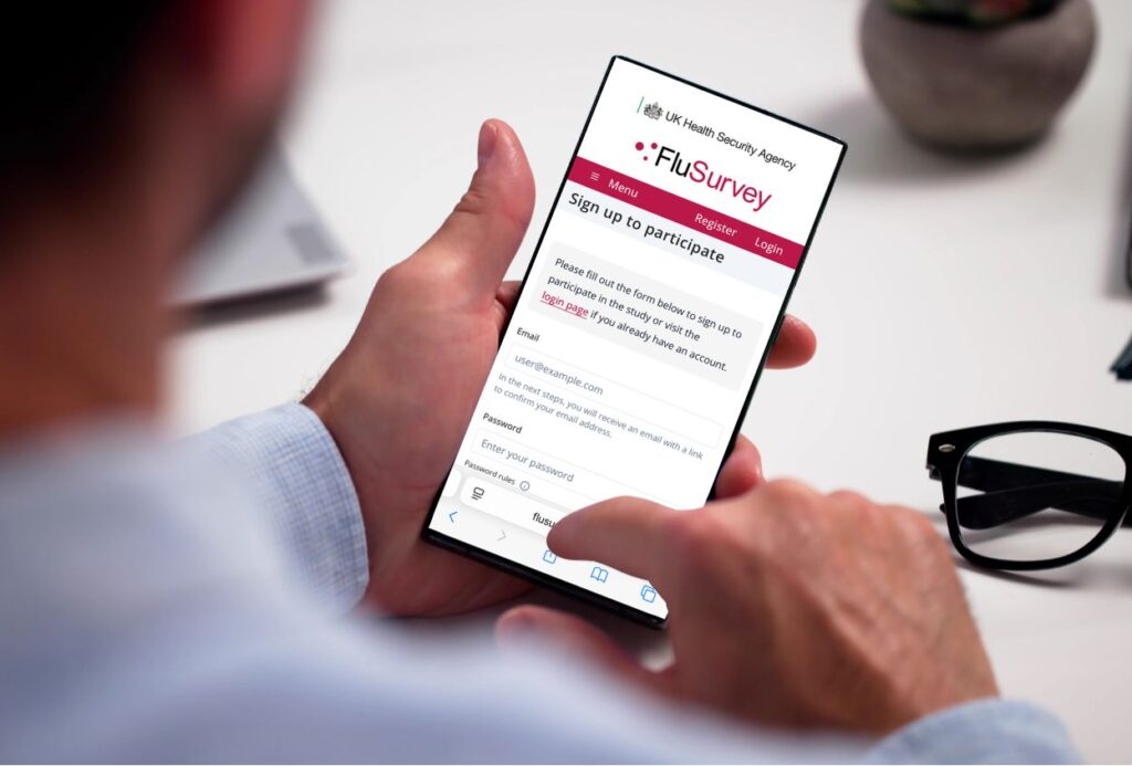 Man holding a phone showing the FluSurvey app