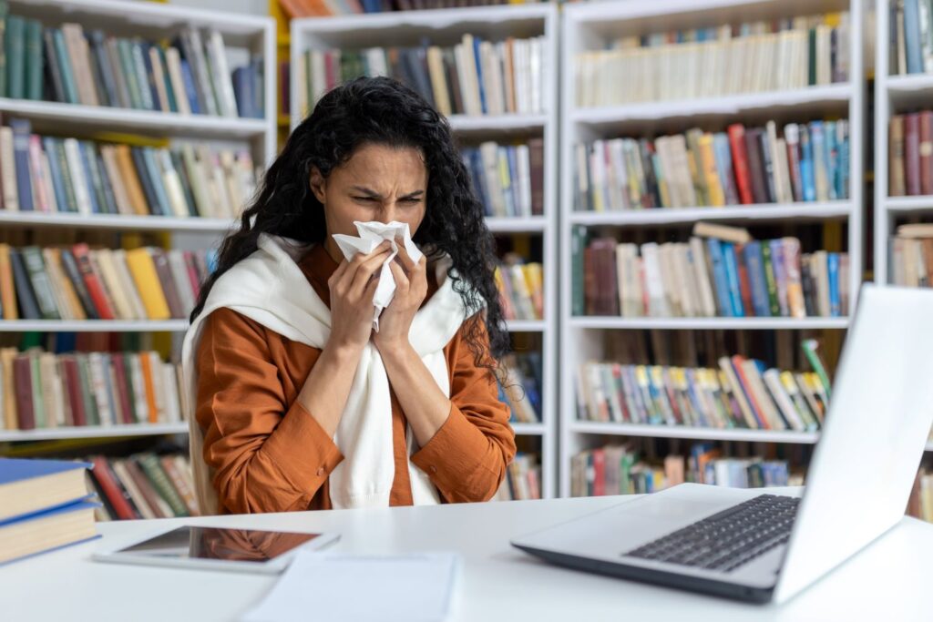 Woman coughing into a handkerchief in a library