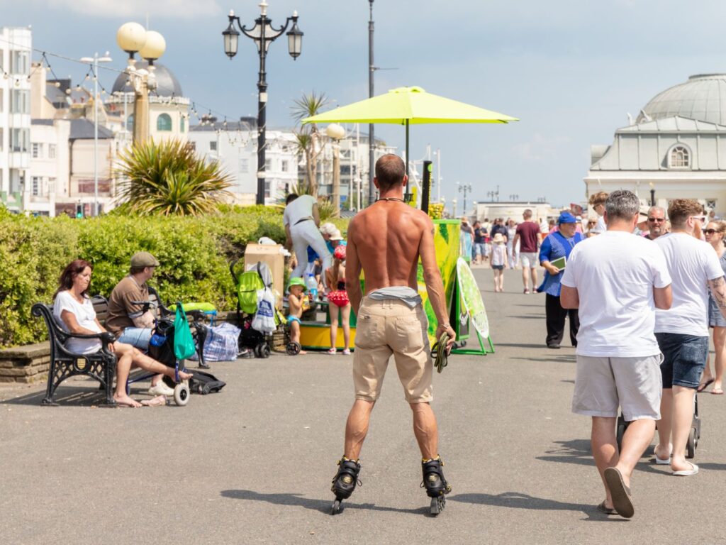 Rear view of shirtless man roller blading along the promenade in Worthing during a spell of hot weather