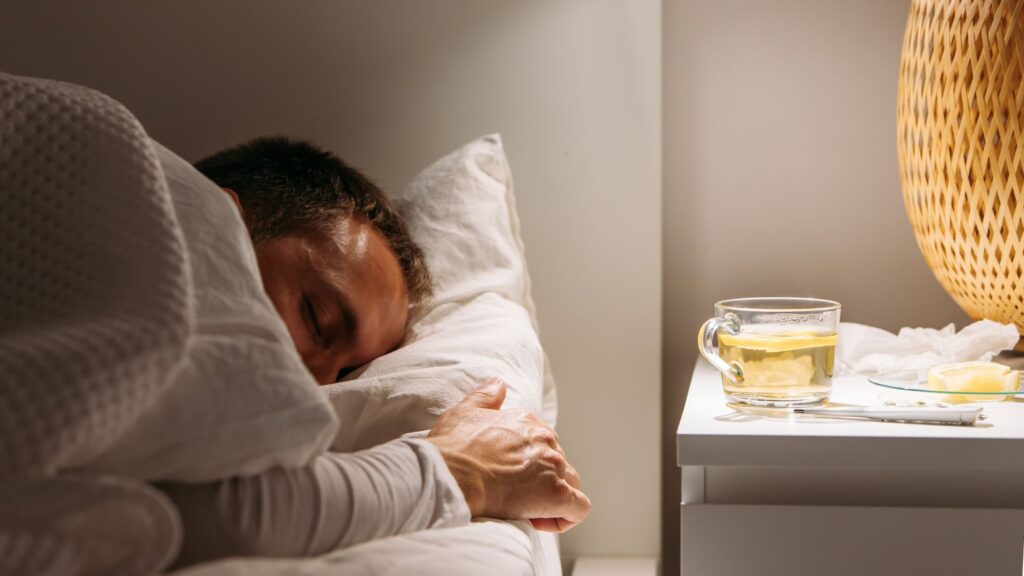 Man lying in bed in darkened room